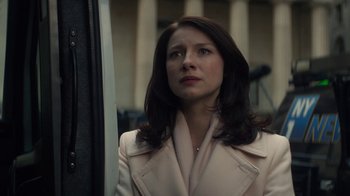 Movie still from “Money Monster” (2016), directed by Jodie Foster – A woman in a white coat looking to her left; Close Up shot, Over the shoulder angle