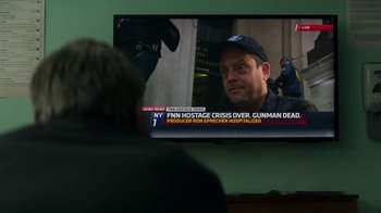 Movie still from “Money Monster” (2016), directed by Jodie Foster – A man sitting in front of a television; Close Up shot, Over the shoulder angle