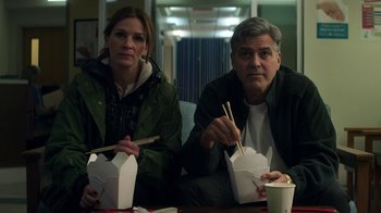 Movie still from “Money Monster” (2016), directed by Jodie Foster – A man and a woman sitting next to each other; Medium shot, Low angle