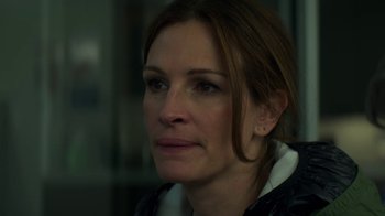 Movie still from “Money Monster” (2016), directed by Jodie Foster – A woman's face in a dark room; Close Up shot, Over the shoulder angle