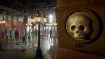 Movie still from “Monster High: The Movie” (2022), directed by Todd Holland – People are walking in a room with lights and a skull; Extreme Close Up shot, Low angle