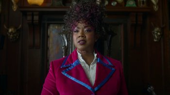 Movie still from “Monster High: The Movie” (2022), directed by Todd Holland – A woman in a pink jacket with a blue ribbon on her head; Close Up shot, Low angle