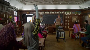Movie still from “Monster High: The Movie” (2022), directed by Todd Holland – A group of people sitting in a room with books; Wide shot, Over the shoulder angle