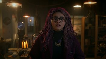 Movie still from “Monster High: The Movie” (2022), directed by Todd Holland – A woman with purple curly hair wearing glasses and a black sweater; Close Up shot, Over the shoulder angle
