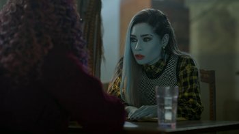 Movie still from “Monster High: The Movie” (2022), directed by Todd Holland – A woman sitting in front of a mirror looking at herself in the mirror; Medium shot, Over the shoulder angle