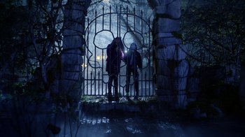 Movie still from “Monster High: The Movie” (2022), directed by Todd Holland – A couple of people standing in front of an iron gate; Wide shot, Over the shoulder angle