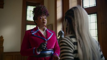 Movie still from “Monster High: The Movie” (2022), directed by Todd Holland – A woman in a red jacket holding a pan in front of another woman; Medium shot, Over the shoulder angle