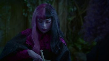 Movie still from “Monster High: The Movie” (2022), directed by Todd Holland – A woman with purple and black hair holding a cane; Close Up shot, Over the shoulder angle