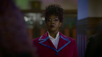 Movie still from “Monster High: The Movie” (2022), directed by Todd Holland – A woman in a red jacket with blue trim looking to her left; Close Up shot, Over the shoulder angle