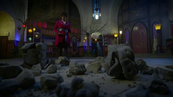 Movie still from “Monster High: The Movie” (2022), directed by Todd Holland – A man in a red coat standing in front of a pile of rocks; Extreme Wide shot, Low angle