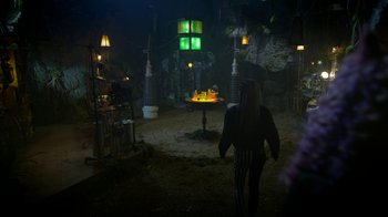 Movie still from “Monster High: The Movie” (2022), directed by Todd Holland – A man standing in a dark room with lights on; Extreme Wide shot, High angle