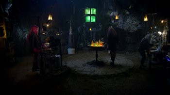 Movie still from “Monster High: The Movie” (2022), directed by Todd Holland – A person standing in a dark room with a table; Extreme Wide shot, High angle
