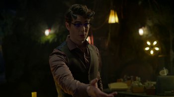 Movie still from “Monster High: The Movie” (2022), directed by Todd Holland – A young man wearing glasses and a brown vest; Medium shot, Over the shoulder angle