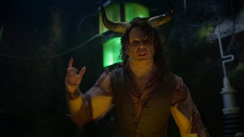 Movie still from “Monster High: The Movie” (2022), directed by Todd Holland – A man with horns on his head is posing for a picture; Medium shot, Over the shoulder angle