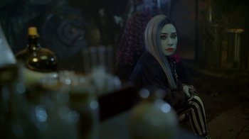 Movie still from “Monster High: The Movie” (2022), directed by Todd Holland – A woman sitting at a table in front of candles; Close Up shot, Over the shoulder angle