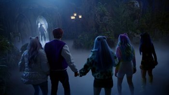 Movie still from “Monster High: The Movie” (2022), directed by Todd Holland – A group of young people holding hands in front of a cave; Wide shot, Over the shoulder angle