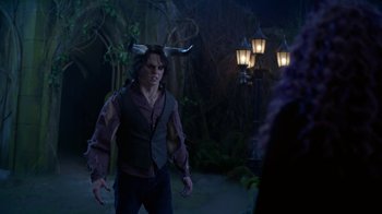 Movie still from “Monster High: The Movie” (2022), directed by Todd Holland – A man with horns on his head standing next to a lamp post; Medium shot, Over the shoulder angle