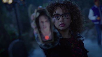 Movie still from “Monster High: The Movie” (2022), directed by Todd Holland – A woman holding up a cell phone with a picture of a man in it; Close Up shot, Over the shoulder angle