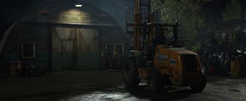 Movie still from “Monster Trucks” (2016), directed by Chris Wedge – A yellow tractor parked in front of a barn; Wide shot, High angle