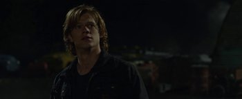 Movie still from “Monster Trucks” (2016), directed by Chris Wedge – A man with long blonde hair wearing a black shirt; Close Up shot, Over the shoulder angle