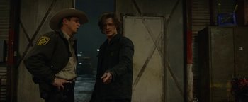 Movie still from “Monster Trucks” (2016), directed by Chris Wedge – Two men standing next to each other in a dark room; Medium shot, Over the shoulder angle