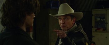 Movie still from “Monster Trucks” (2016), directed by Chris Wedge – A man wearing a cowboy hat pointing at another man; Close Up shot, Over the shoulder angle