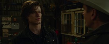 Movie still from “Monster Trucks” (2016), directed by Chris Wedge – A man in a black jacket is standing in a room; Close Up shot, Over the shoulder angle