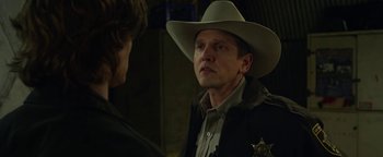 Movie still from “Monster Trucks” (2016), directed by Chris Wedge – A man wearing a cowboy hat talking to another man; Close Up shot, Over the shoulder angle