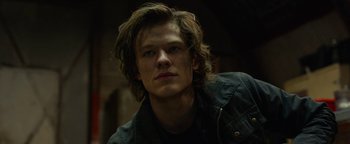 Movie still from “Monster Trucks” (2016), directed by Chris Wedge – A man with long brown hair wearing a black shirt; Close Up shot, Low angle