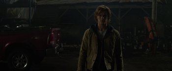 Movie still from “Monster Trucks” (2016), directed by Chris Wedge – A man standing in the dark in front of a building; Medium shot, Over the shoulder angle