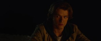 Movie still from “Monster Trucks” (2016), directed by Chris Wedge – A man with long blonde hair wearing a brown jacket; Close Up shot, Over the shoulder angle