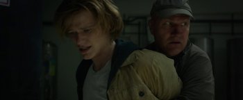 Movie still from “Monster Trucks” (2016), directed by Chris Wedge – A man and a woman standing next to each other in a room; Medium shot, Over the shoulder angle