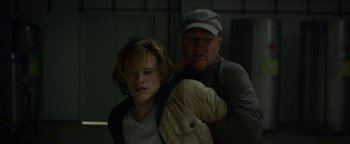 Movie still from “Monster Trucks” (2016), directed by Chris Wedge – A man and a boy in a dark room; Medium shot, Over the shoulder angle