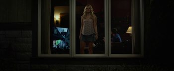 Movie still from “Monster Trucks” (2016), directed by Chris Wedge – A woman standing in front of a window at night; Wide shot, Low angle