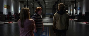 Movie still from “Monster Trucks” (2016), directed by Chris Wedge – A group of people standing in a warehouse; Medium shot, Over the shoulder angle