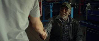 Movie still from “Monster Trucks” (2016), directed by Chris Wedge – An older man is shaking hands with a younger man; Medium shot, Over the shoulder angle