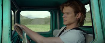 Movie still from “Monster Trucks” (2016), directed by Chris Wedge – A young man driving a car on a road; Close Up shot, Low angle