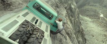 Movie still from “Monster Trucks” (2016), directed by Chris Wedge – A man is climbing up the side of a truck; Wide shot, Overhead angle