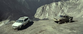 Two cars parked on top of a hill