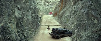 Movie still from “Monster Trucks” (2016), directed by Chris Wedge – A man walking down a dirt road next to a truck; Extreme Wide shot, High angle