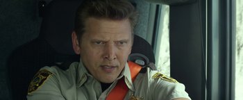 Movie still from “Monster Trucks” (2016), directed by Chris Wedge – A person in a car wearing a uniform; Close Up shot, Over the shoulder angle