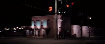 Movie still from “Monster's Ball” (2001), directed by Marc Forster – A red traffic light sitting on the side of a building; Extreme Wide shot, Low angle