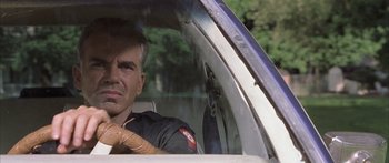 Movie still from “Monster's Ball” (2001), directed by Marc Forster – A police officer sitting in a car in the driver's seat; Close Up shot, Over the shoulder angle