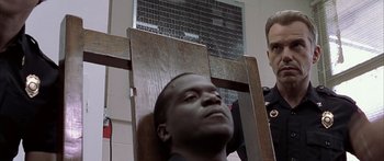 Movie still from “Monster's Ball” (2001), directed by Marc Forster – A man is sitting in a chair in front of another man; Close Up shot, Over the shoulder angle