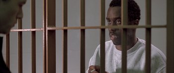 Movie still from “Monster's Ball” (2001), directed by Marc Forster – A man sitting behind bars in a jail cell; Close Up shot, High angle