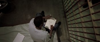 Movie still from “Monster's Ball” (2001), directed by Marc Forster – A man sitting on the ground drawing a picture; Close Up shot, Overhead angle