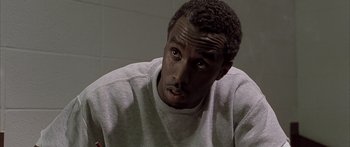 Movie still from “Monster's Ball” (2001), directed by Marc Forster – A person sitting down with his eyes wide open; Close Up shot, Low angle