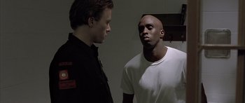 Movie still from “Monster's Ball” (2001), directed by Marc Forster – Two men standing next to each other in front of a wall; Medium shot, Low angle