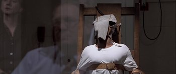 Movie still from “Monster's Ball” (2001), directed by Marc Forster – A man in a white shirt is tied to a wooden chair; Close Up shot, High angle