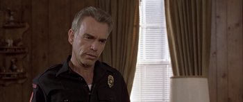 Movie still from “Monster's Ball” (2001), directed by Marc Forster – A man in a police uniform looking to his left; Close Up shot, Low angle